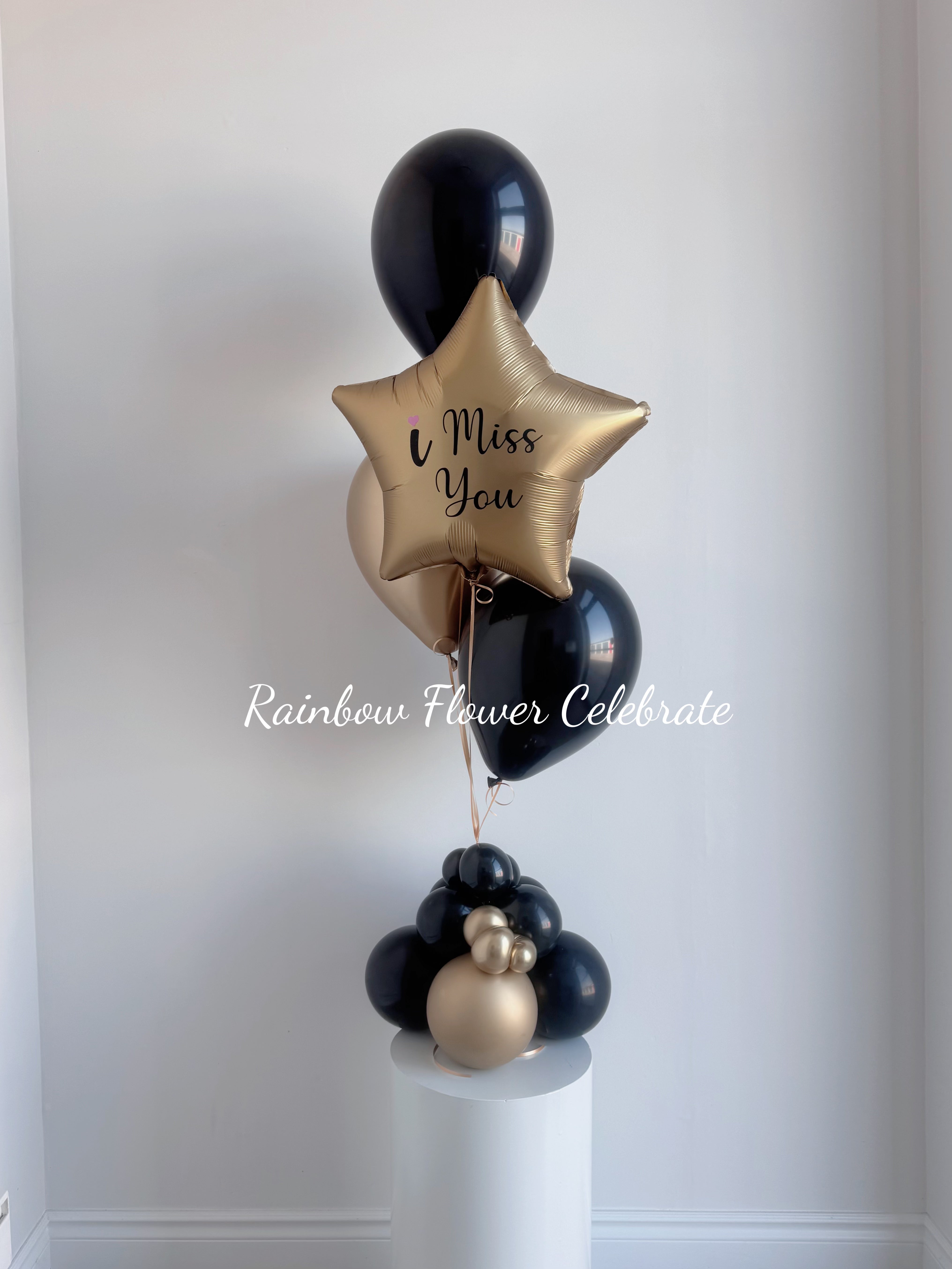 Black and gold helium balloon with i miss you message on a gold star balloon